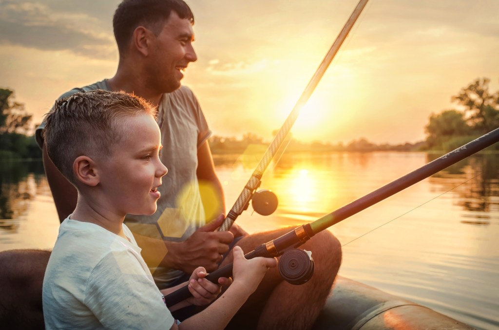 man fishing with boy - smiling making memories
