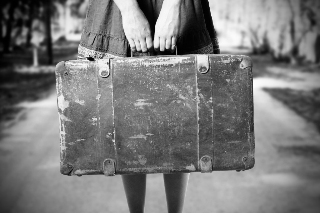 girls hands holding an old suitcase
